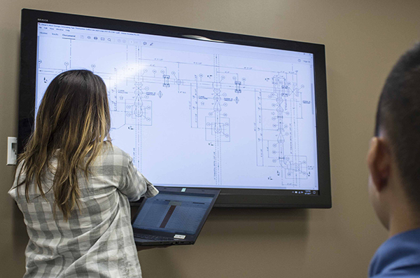 An engineer reviews a drawing on a computer screen